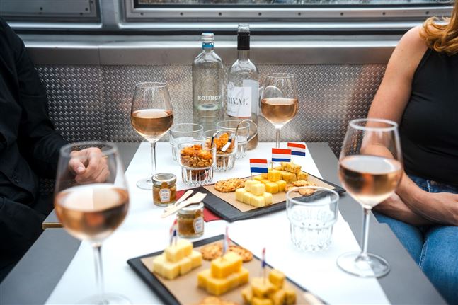 Mesa cubierta durante un crucero de queso y vino por el canal con Canal Tours Amsterdam