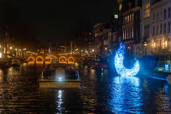Een Canal Tours Amsterdam rondvaart langs een prachtig blauw licht kunstwerk